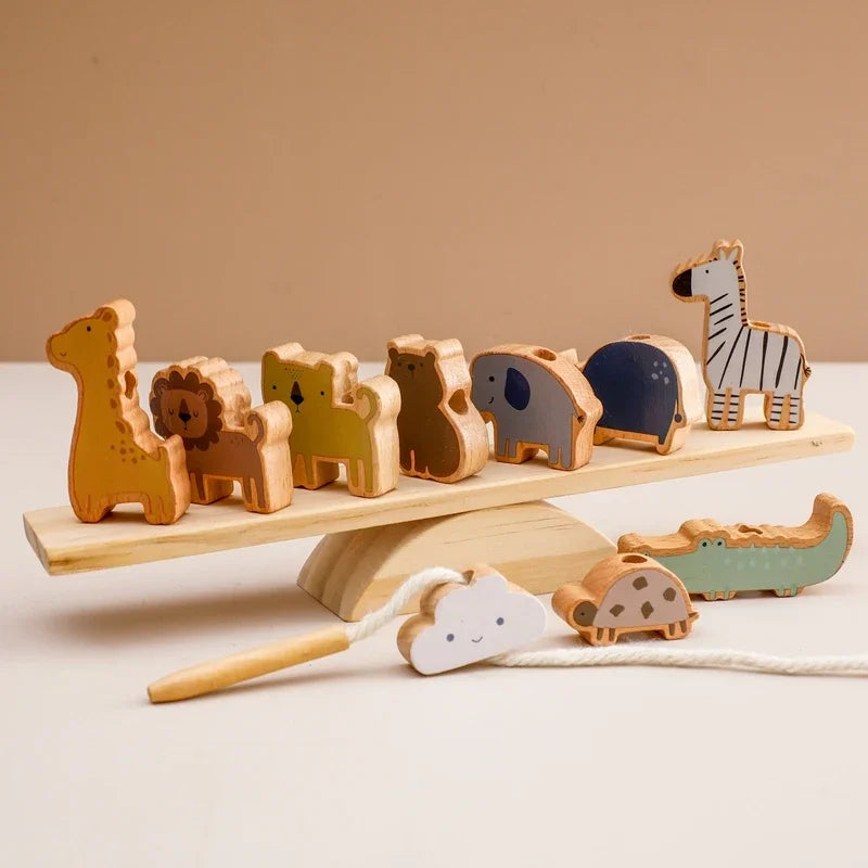 Set of wooden animal toys on a balance scale with a plain background