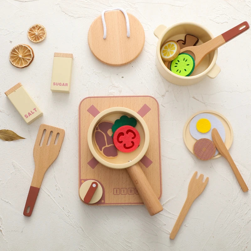 Set of wooden toy kitchen items including pots, pans, utensils, and food items on a white surface.