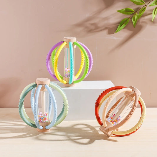 Colorful baby rattle toys on a neutral background with a branch in the corner.