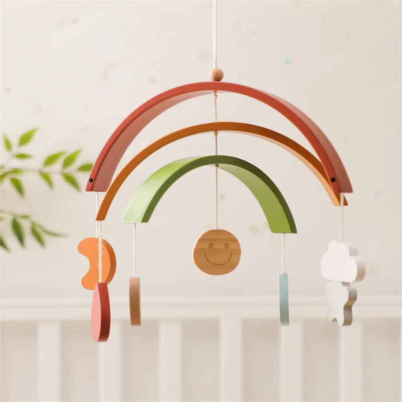Colorful wooden rainbow mobile with hanging shapes against a light background